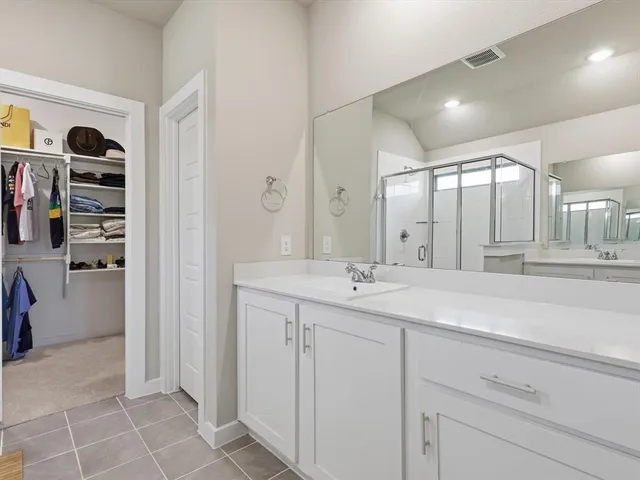 a spacious bathroom with a double vanity sink and a mirror