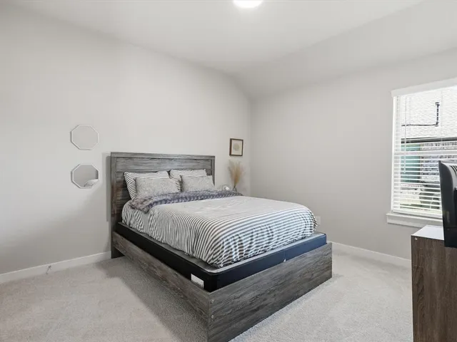 a bed sitting in a bedroom next to a window