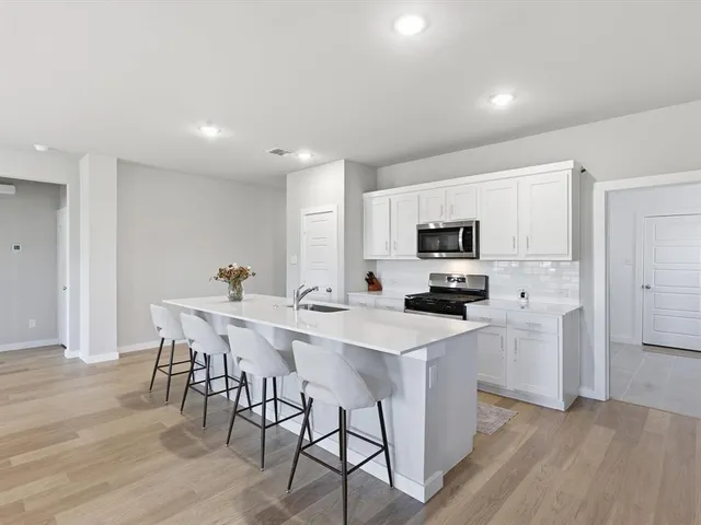 a kitchen with stainless steel appliances a microwave sink and refrigerator