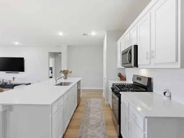 a kitchen with stainless steel appliances a sink stove and microwave