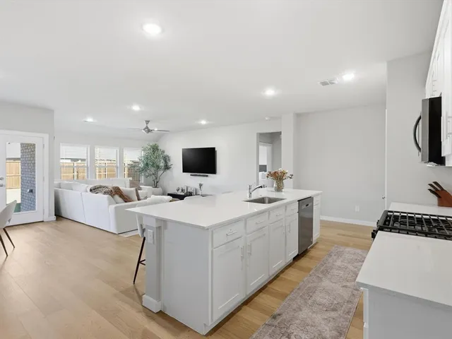 a kitchen with a sink and white cabinets