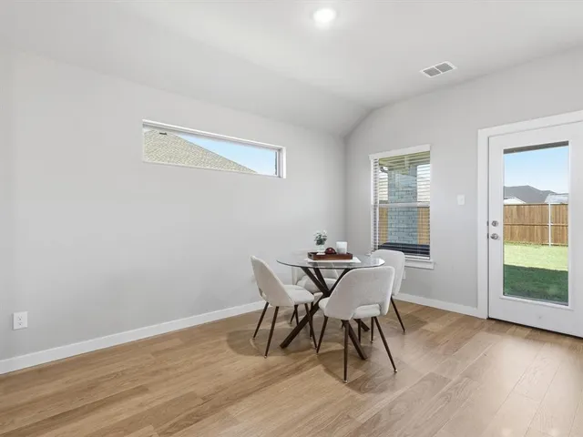 a dining room with furniture and wooden floor