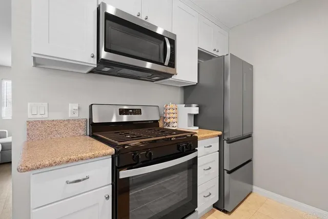 a kitchen with stainless steel appliances granite countertop a sink stove and microwave