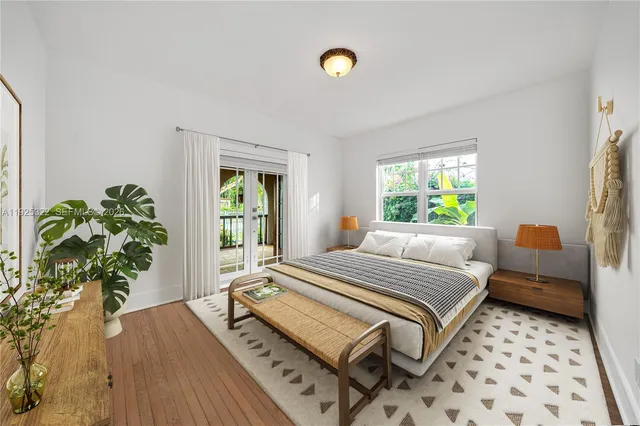 a bedroom with a bed table flowerpot and window