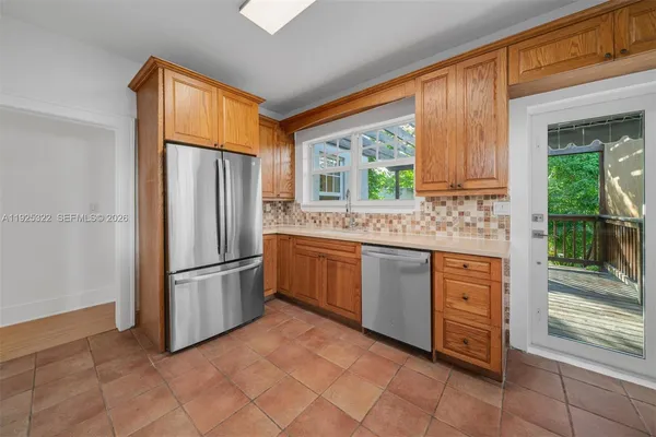 a kitchen with stainless steel appliances granite countertop a refrigerator and a sink
