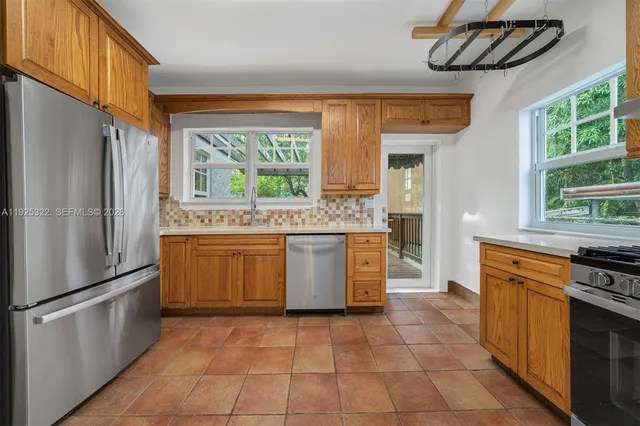 a kitchen with stainless steel appliances granite countertop a stove a sink and a refrigerator
