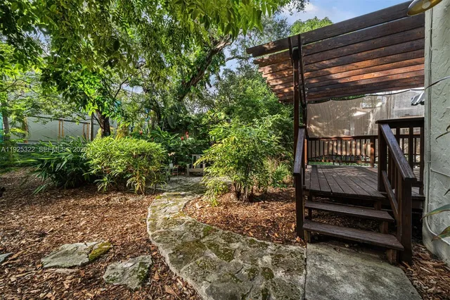a view of backyard with wooden fence and a large tree