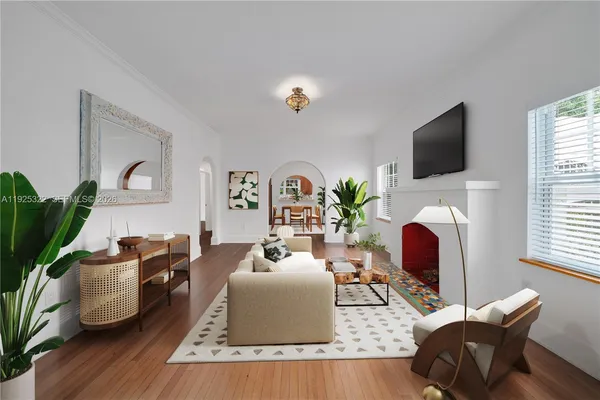 a living room with furniture a flat screen tv and a fireplace