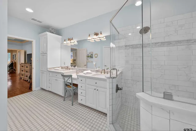 a spacious bathroom with a double vanity sink a mirror and shower