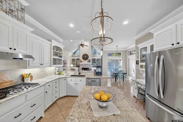 a kitchen with stainless steel appliances a sink a stove a refrigerator and cabinets