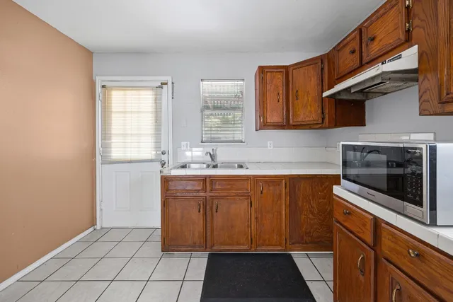 a kitchen with stainless steel appliances granite countertop a sink stove and microwave
