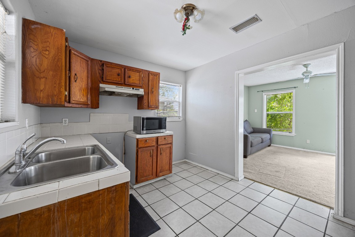 908 Vargas Road Austin, TX 78741 - Photo 17 of 28 a kitchen with a sink cabinets and utility