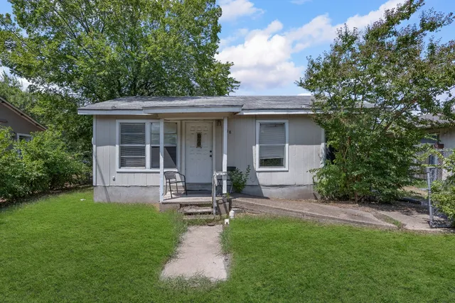 a view of a house with a yard and sitting area