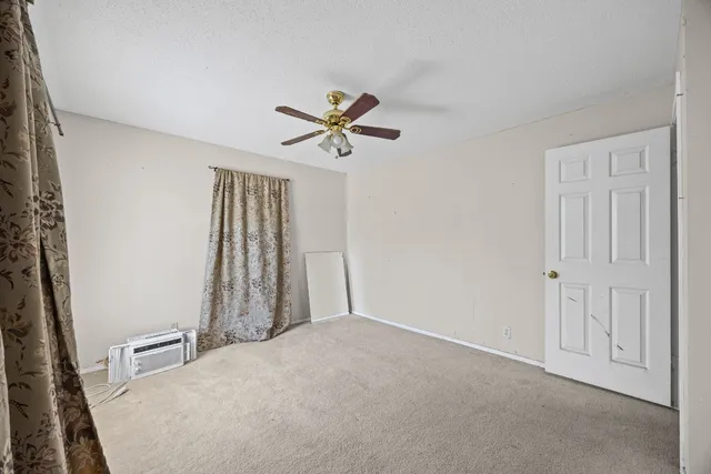 an empty room with closet and a ceiling fan