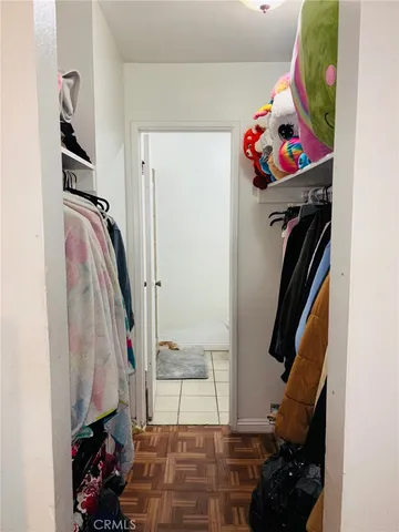 a view of walk in closet with clothes and shoes