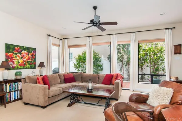 a living room with furniture a rug and a large window