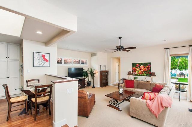 a living room with furniture a flat screen tv and a table