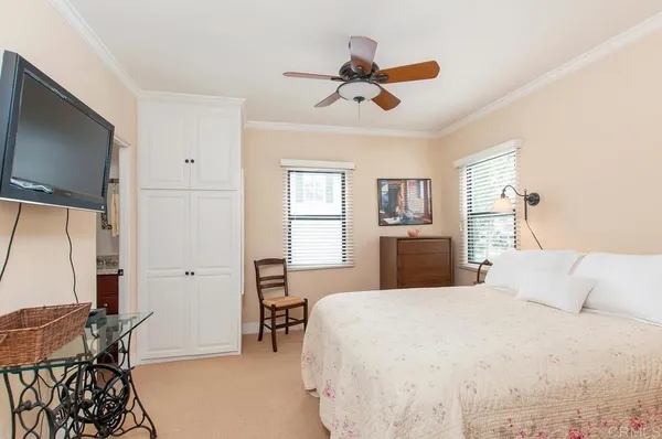 a bedroom with a bed and furniture with a flat tv screen