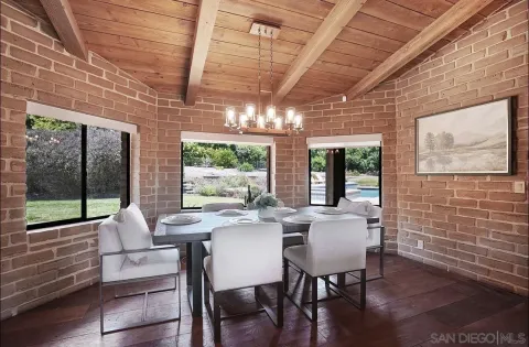 a dining room with furniture large windows and wooden floor