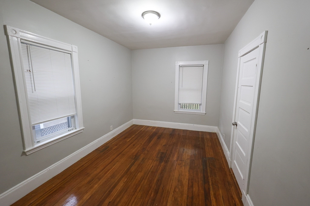 82 Fuller Street, Unit 1 Boston, MA 02124 - Photo 12 of 13 an empty room with wooden floor and windows