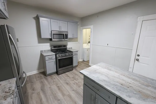 a kitchen with granite countertop a sink stove and refrigerator