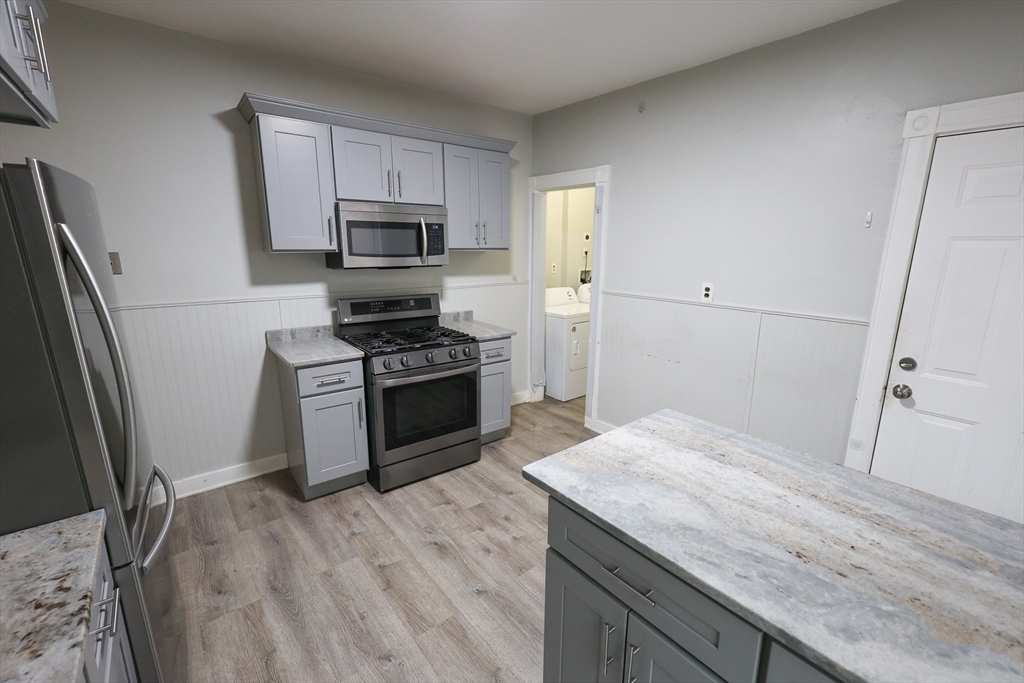 82 Fuller Street, Unit 1 Boston, MA 02124 - Photo 4 of 13 a kitchen with granite countertop a sink stove and refrigerator