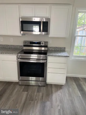 a stove top oven sitting inside of a kitchen