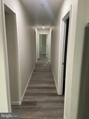 a view of a hallway with wooden floor and entryway
