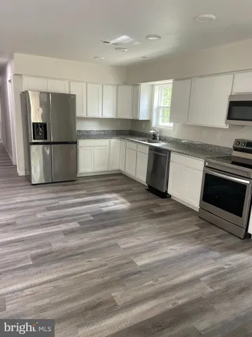 a kitchen with granite countertop a refrigerator and a sink