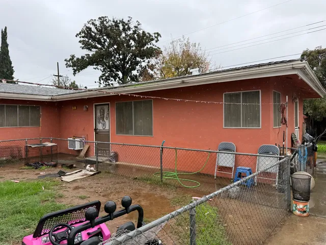 a backyard of a house with wooden fence and a fountain