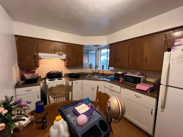 a kitchen with granite countertop a sink appliances a counter space and cabinets
