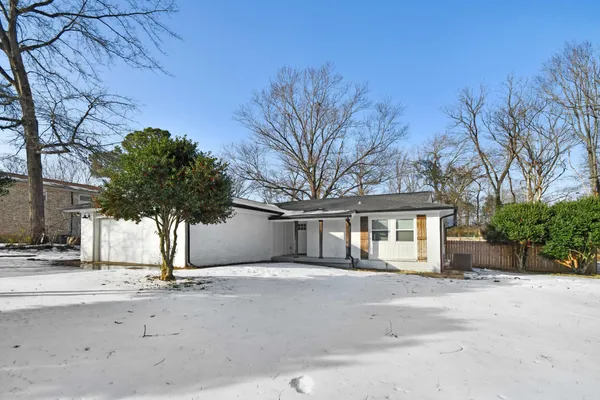 a front view of a house with a tree