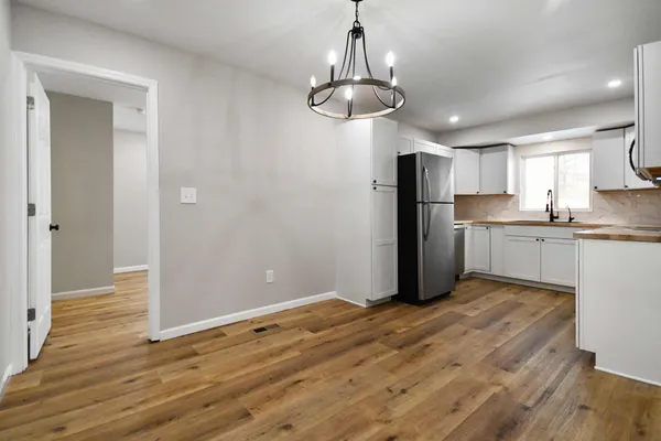 a view of a kitchen with a sink and dishwasher a refrigerator with wooden floor