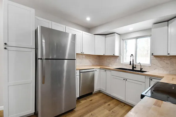 a kitchen with stainless steel appliances granite countertop a refrigerator and a sink