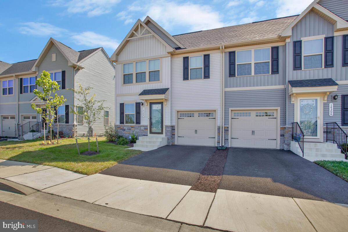 14304 Longhouse Loop, Unit A Brandywine, MD 20613 - Photo 4 of 72 a front view of a house with a yard and a garage