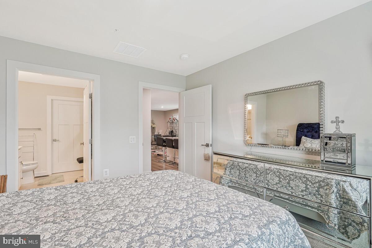 14304 Longhouse Loop, Unit A Brandywine, MD 20613 - Photo 65 of 72 a bedroom with a bed and a dresser in it