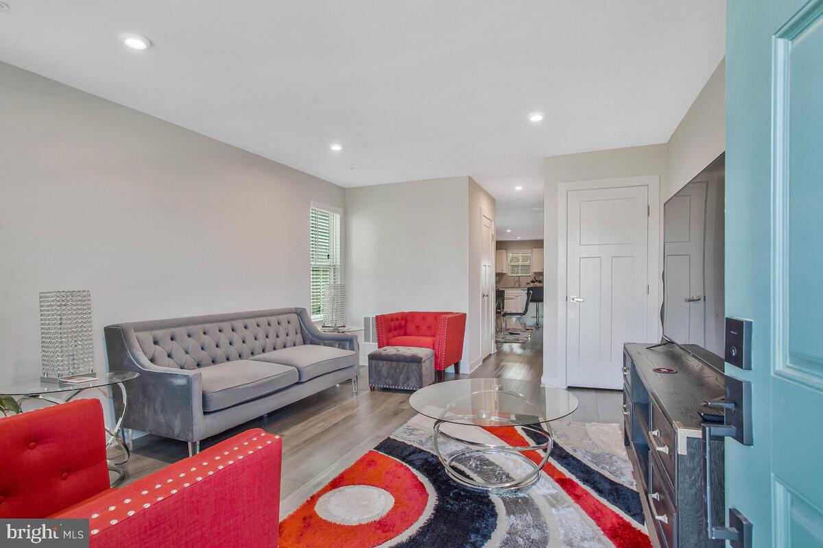 14304 Longhouse Loop, Unit A Brandywine, MD 20613 - Photo 7 of 72 a living room with furniture and a wooden floor