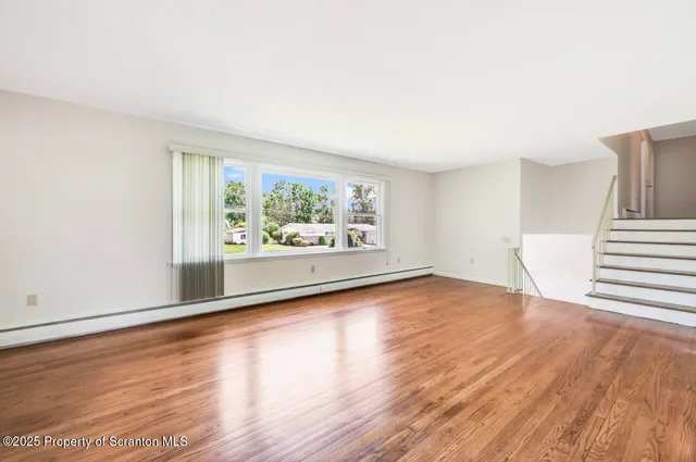 a large kitchen with stainless steel appliances granite countertop a large counter top and a wooden floors