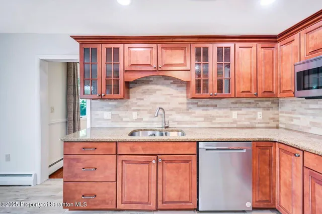 a kitchen with stainless steel appliances granite countertop a stove a sink dishwasher a refrigerator and a oven with wooden floor