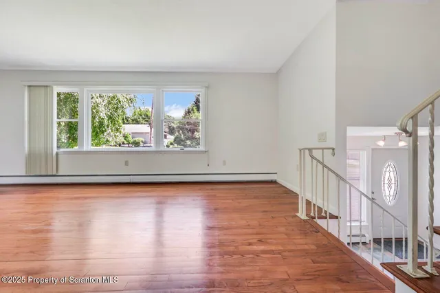 a view of an empty room with wooden floor