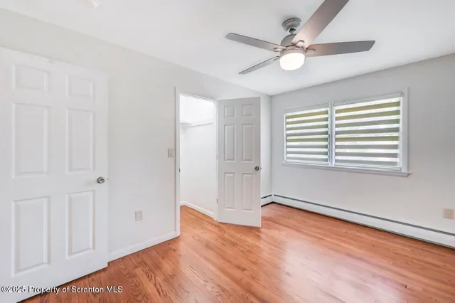 a view of an empty room with wooden floor