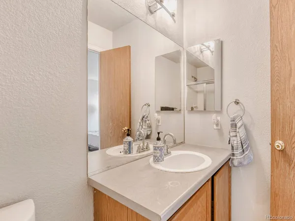 a bathroom with a sink and a mirror with toilet