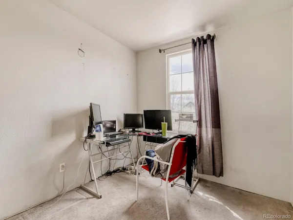a view of a workspace with furniture and a window