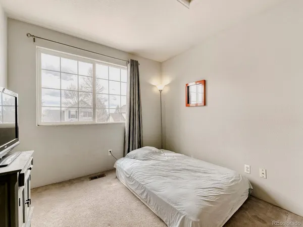 a bedroom with a bed and a flat tv screen on the dresser