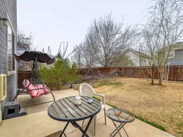 a backyard of a house with barbeque oven table and chairs