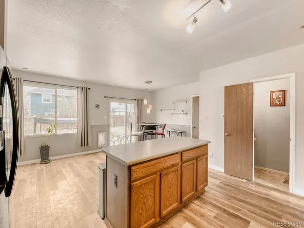 a kitchen with a stove a refrigerator a sink and dishwasher with wooden floor