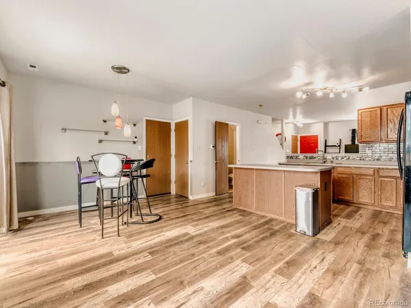 a kitchen with stainless steel appliances kitchen island granite countertop a sink cabinets and wooden floor