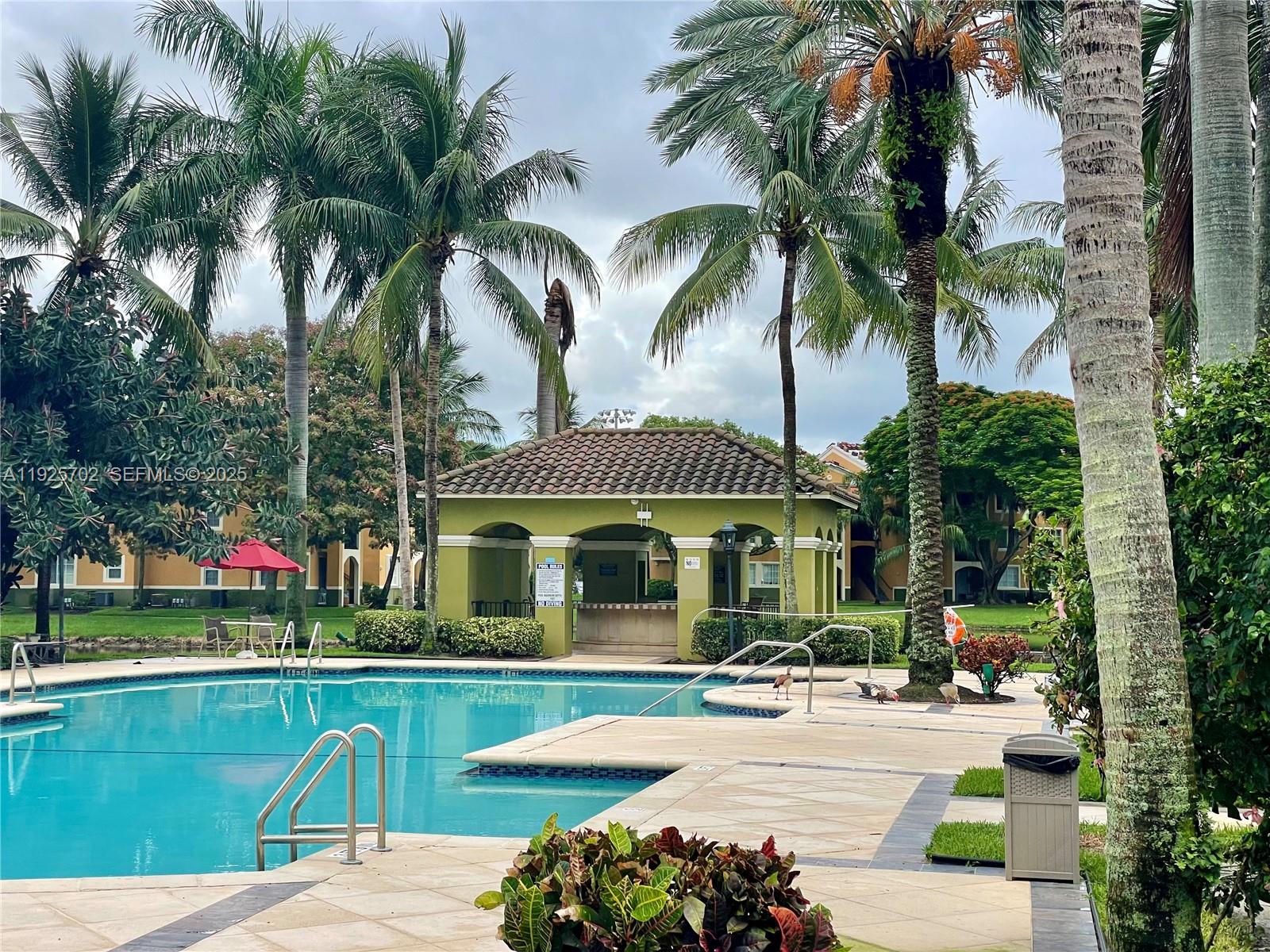 2080 West Preserve Way, Unit 207 Miramar, FL 33025 - Photo 12 of 20 a view of a swimming pool with a table and chairs