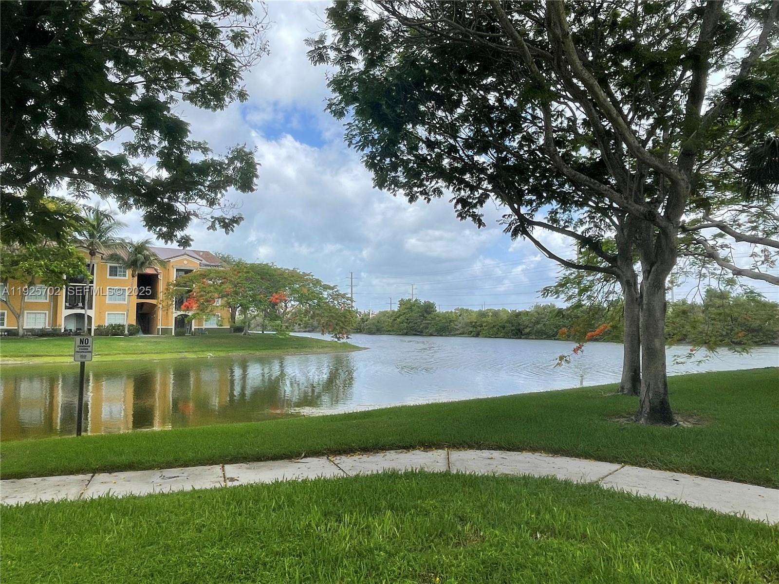 2080 West Preserve Way, Unit 207 Miramar, FL 33025 - Photo 17 of 20 a view of a lake with a yard and large trees