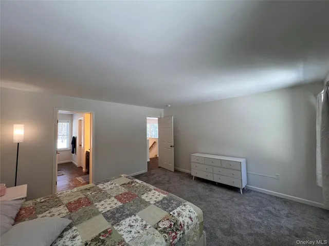 a bedroom with a bed and a lamp on desk